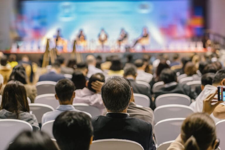Rear view of Audience listening Speakers on the stage in the con